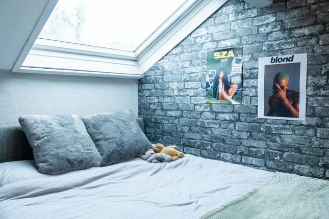 A Cozy Bedroom Featuring A Neatly Made Bed With Pi...