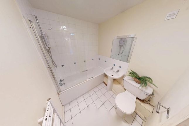A Clean And Bright Bathroom Featuring A White Tile...