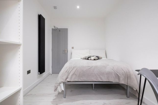 A Bright And Tidy Single Bedroom Featuring A Comfo...
