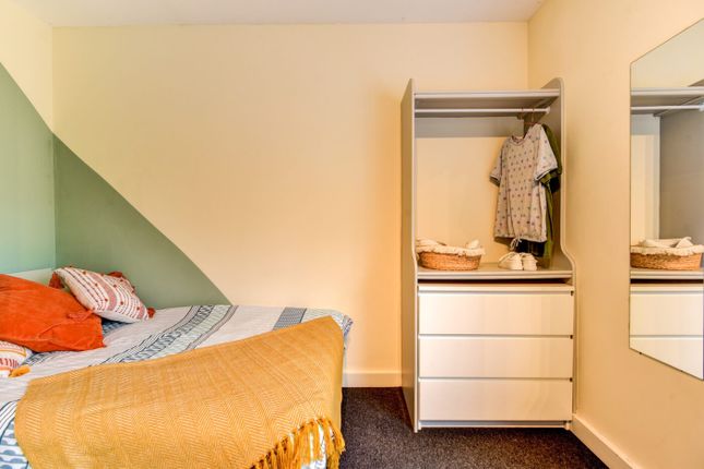 A Cozy Bedroom Featuring A Neatly Made Bed With Co...