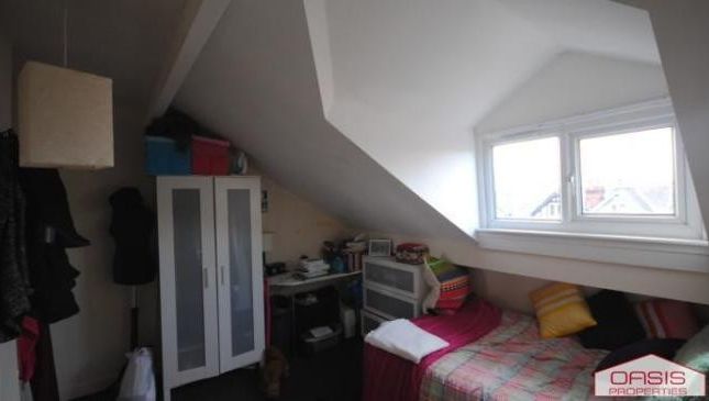 A Cozy Bedroom With A Sloped Ceiling, Featuring A ...