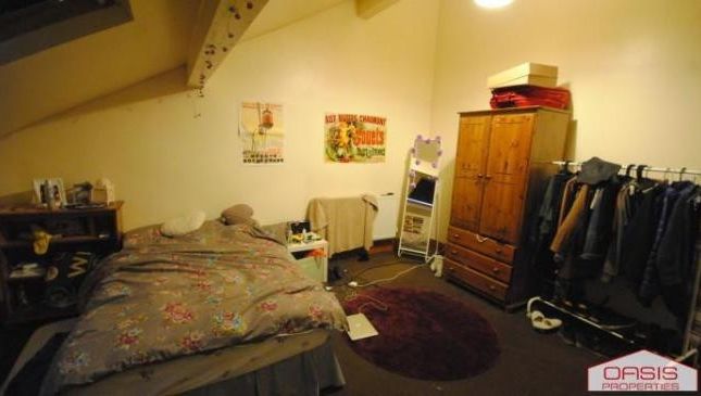 A Comfortable Bedroom Featuring A Double Bed And P...