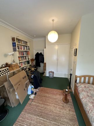 A Cozy Double Bedroom Featuring A Stylish Bookshel...
