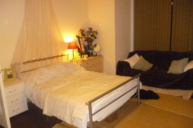 A Cozy Bedroom Featuring A Double Bed With A Simpl...