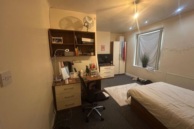 A Cozy Bedroom Featuring A Single Bed, A Desk With...