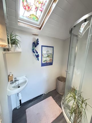 A Bright And Tidy Bathroom With A Corner Shower, A...