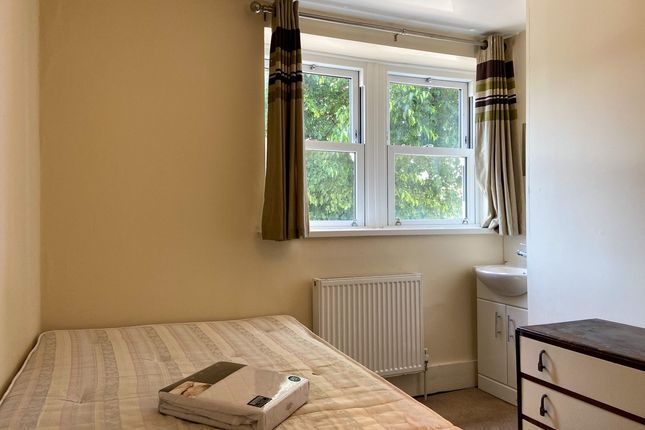 A Cozy Bedroom Featuring A Double Bed With A Bedsi...