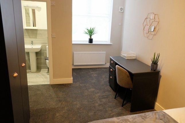 A Cozy Single Bedroom Featuring A Desk And Chair P...