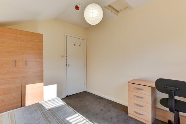 A Neat And Well-Lit Bedroom With A Comfortable Bed...