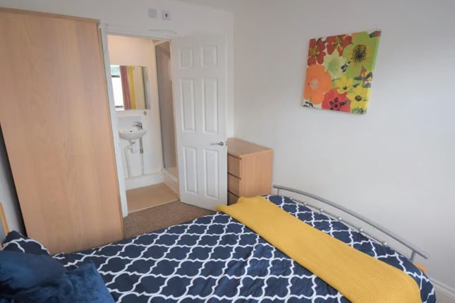 Cozy Double Bedroom Featuring A Vibrant Floral Acc...