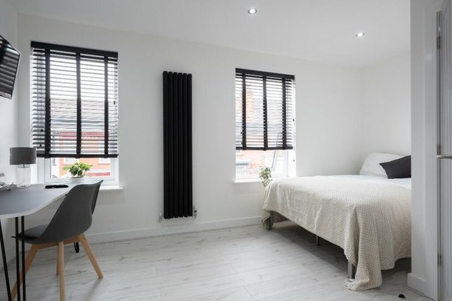 A Bright And Clean Bedroom Featuring Two Large Win...