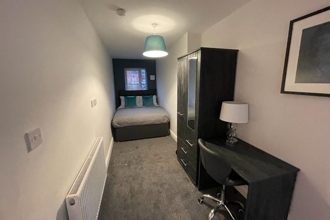 A Neat And Compact Bedroom Featuring A Single Bed,...