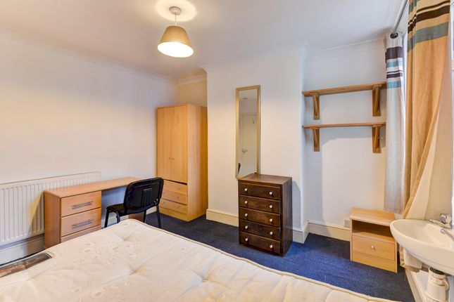 A Cozy Bedroom Featuring A Bed, Wardrobe, And A Sm...