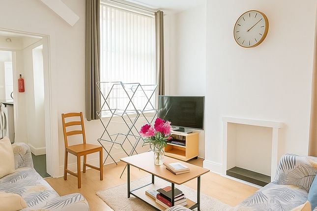 A Bright And Inviting Living Room Featuring Comfor...