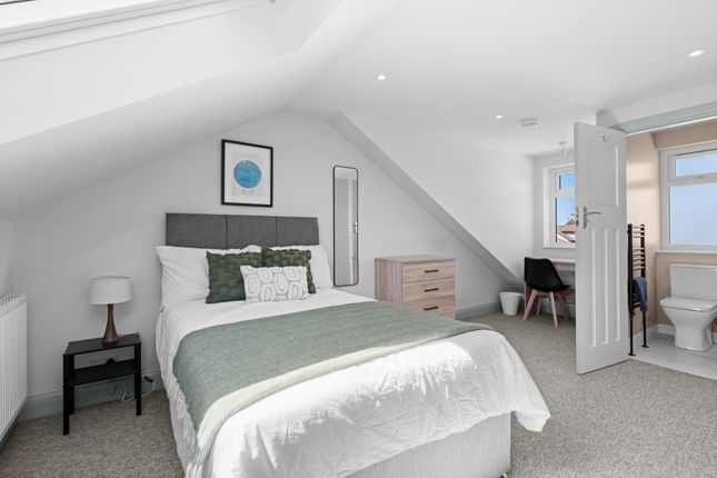 A Bright, Modern Master Bedroom Featuring A Comfor...