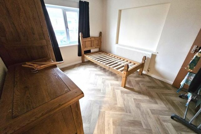 A Tidy Single Bedroom Featuring A Wooden Bed Frame...