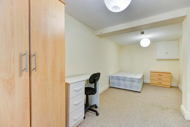 A Cozy Bedroom With A Single Bed And A Small Study...