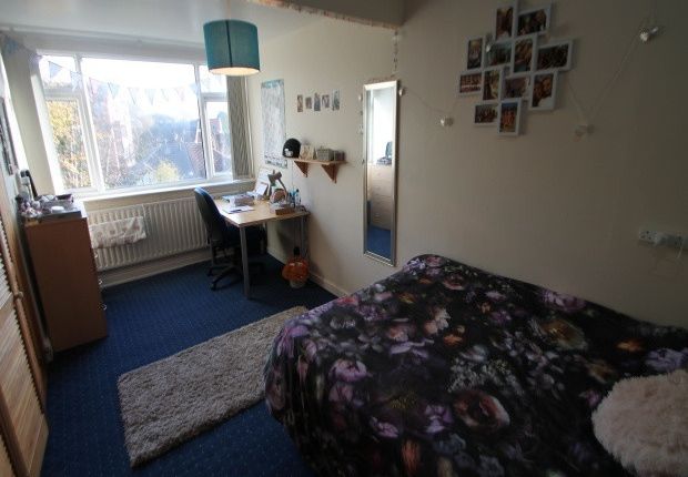 A Cozy Bedroom Featuring A Large Bed With Floral B...