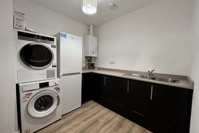 A Modern Kitchenette Featuring Sleek Cabinets, Ess...