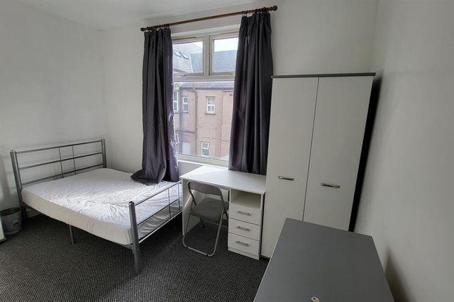 A Neat, Well-Lit Single Bedroom Featuring A Metal ...