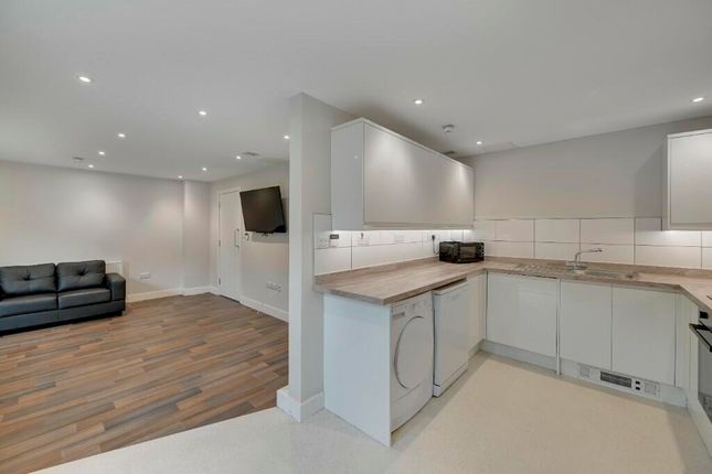 A Modern Open-Plan Living Room With Sleek White Ki...