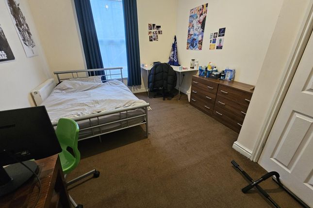 A Cozy Student Bedroom Featuring A Single Bed, A d...