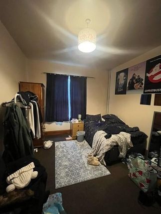 A Cozy Living Room With A Window Covered By Dark c...
