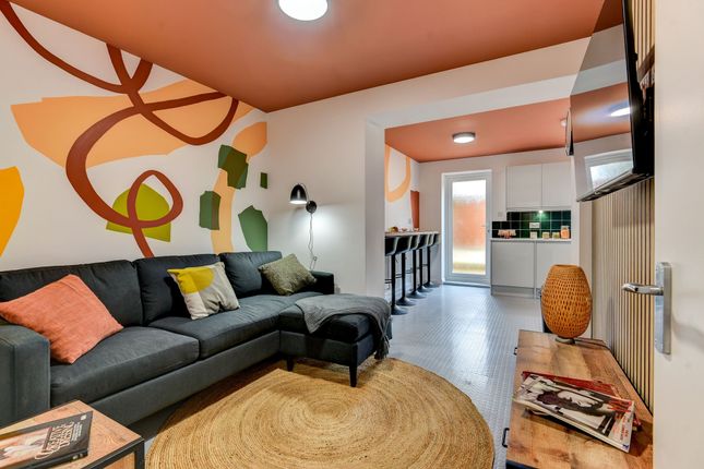 A Stylish Living Room Featuring A Comfortable Dark...
