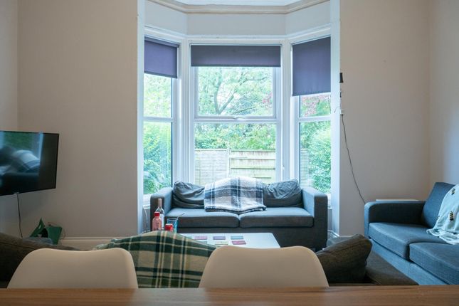 A Well-Lit And Inviting Living Room Featuring Ampl...