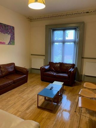 A Cozy Living Room Featuring Warm Wooden Floors, T...