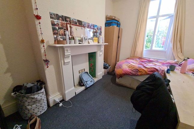 A Cozy Bedroom Featuring A Bed With Colorful Beddi...