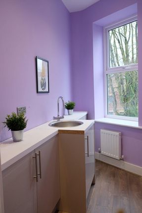 A Well-Maintained Kitchen With Bright Purple Walls...