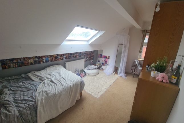 A Cozy Single Bedroom Featuring A Sloped Ceiling W...