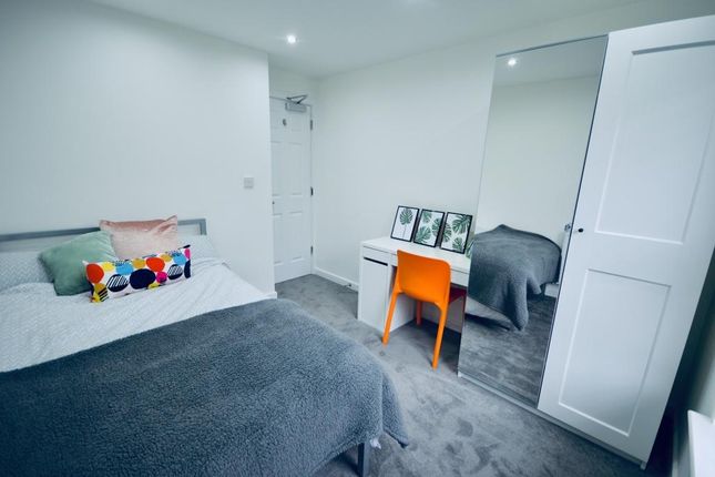 A Tidy And Well-Lit Bedroom Featuring A Comfortabl...