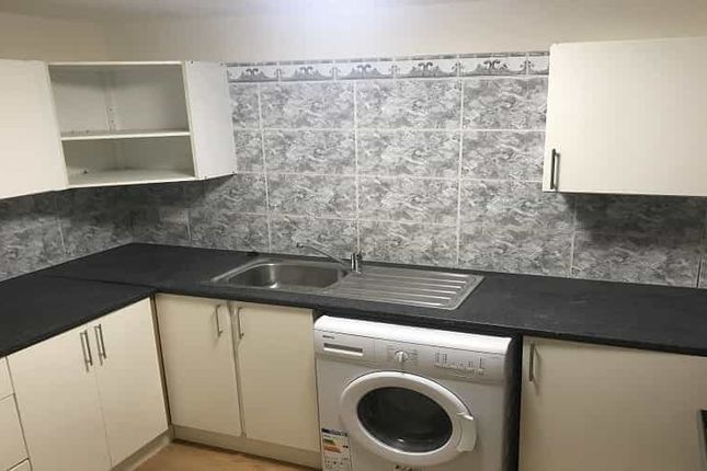 A Compact, Modern Kitchen With White Cabinets, Gre...