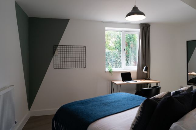 A Stylish Double Bedroom Featuring Ample Natural l...