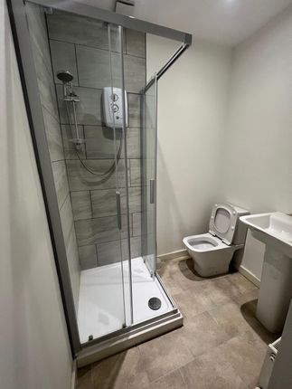 A Modern Bathroom Featuring A Glass-Enclosed Showe...