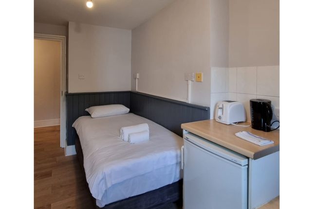 A Tidy And Inviting Single Bedroom With Essential ...