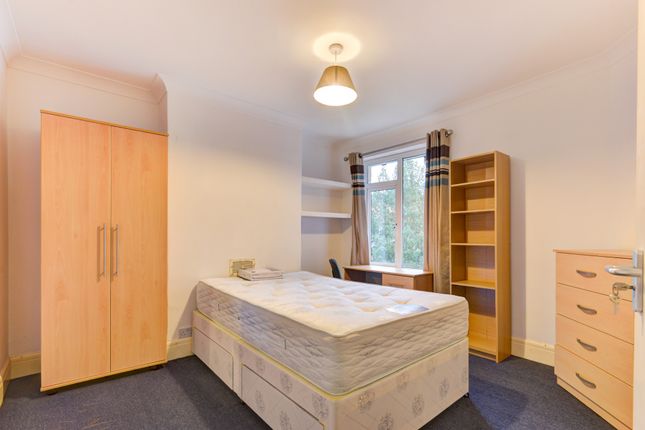 A Well-Lit, Tidy Bedroom Featuring A Comfortable d...