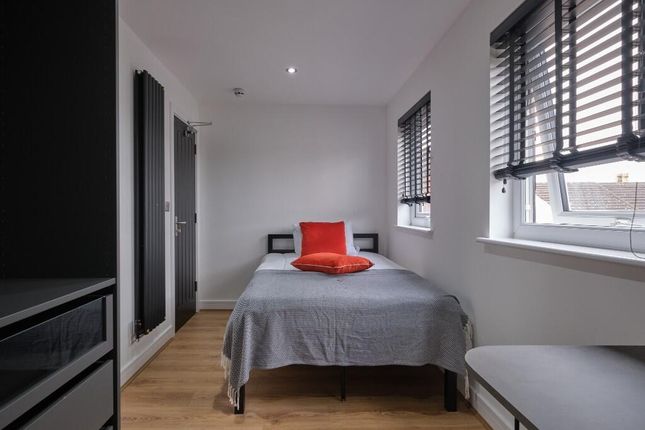 A Bright And Tidy Bedroom Featuring Two Large Wind...