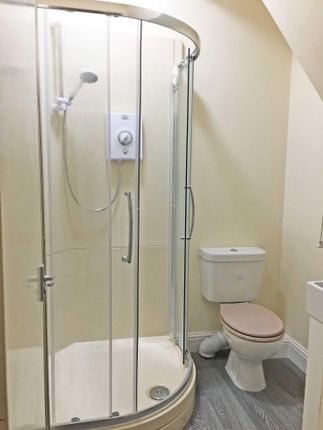 Bright, Tidy Bathroom Featuring A Curved-Glass Sho...