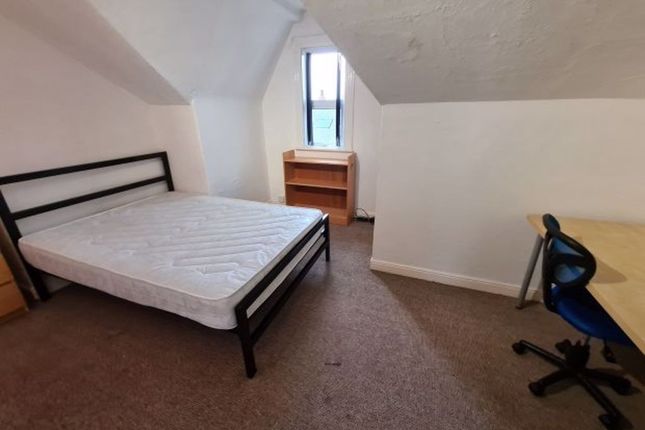 A Cozy Bedroom Featuring A Metal-Framed Single Bed...