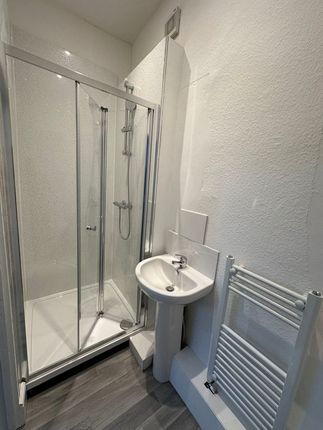 A Clean And Modern Bathroom Featuring A Corner Sho...