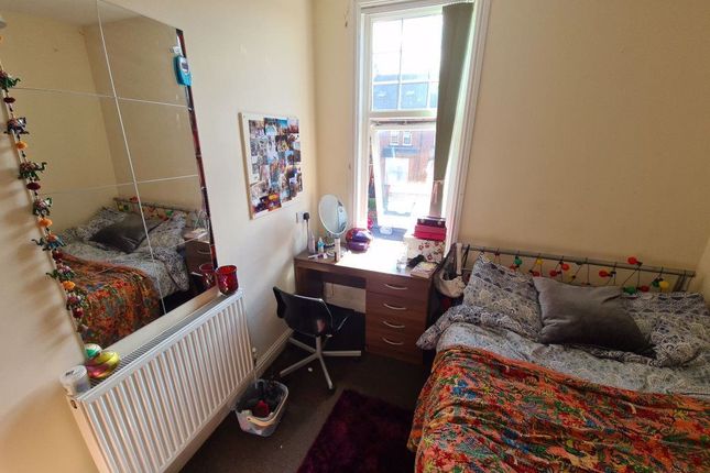 A Cozy Bedroom Featuring A Double Bed With Pattern...