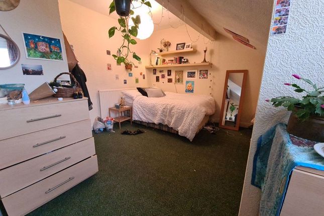 A Cozy Bedroom Featuring A Single Bed, A Storage U...