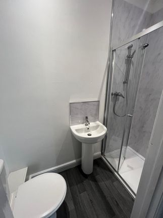 A Modern Bathroom Featuring A Sleek White Pedestal...