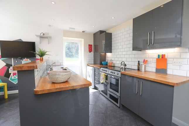 A Modern Kitchen Featuring Sleek Grey Cabinets And...