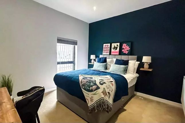 A Stylish Master Bedroom Featuring A Comfortable d...