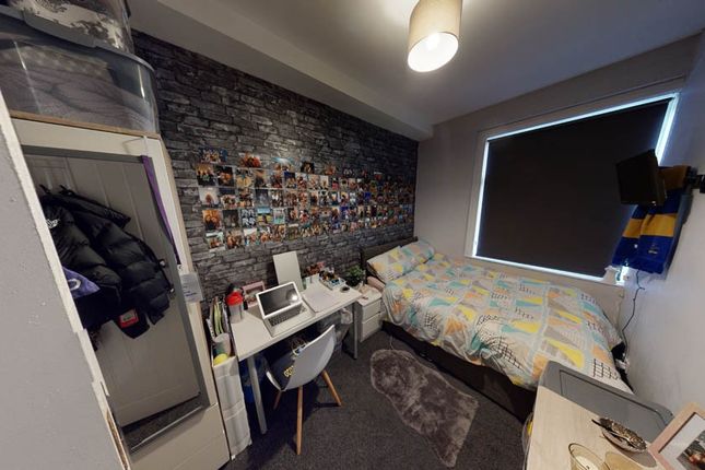 A Cozy Single Bedroom Featuring A Neatly Made Bed,...