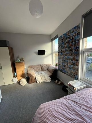 Bright, Comfortable Bedroom Featuring A Cozy Sofa,...